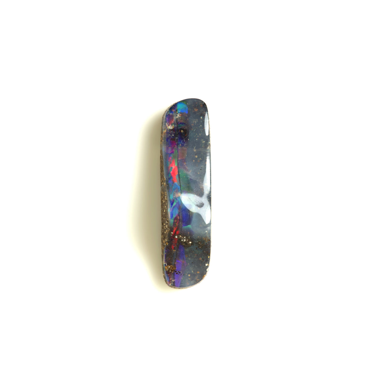 A polished rectangular opal gemstone with a dark gray to black base showing vibrant flashes of blue, purple, red, and white, accented with ironstone host rock flecks, set against a plain white background.
