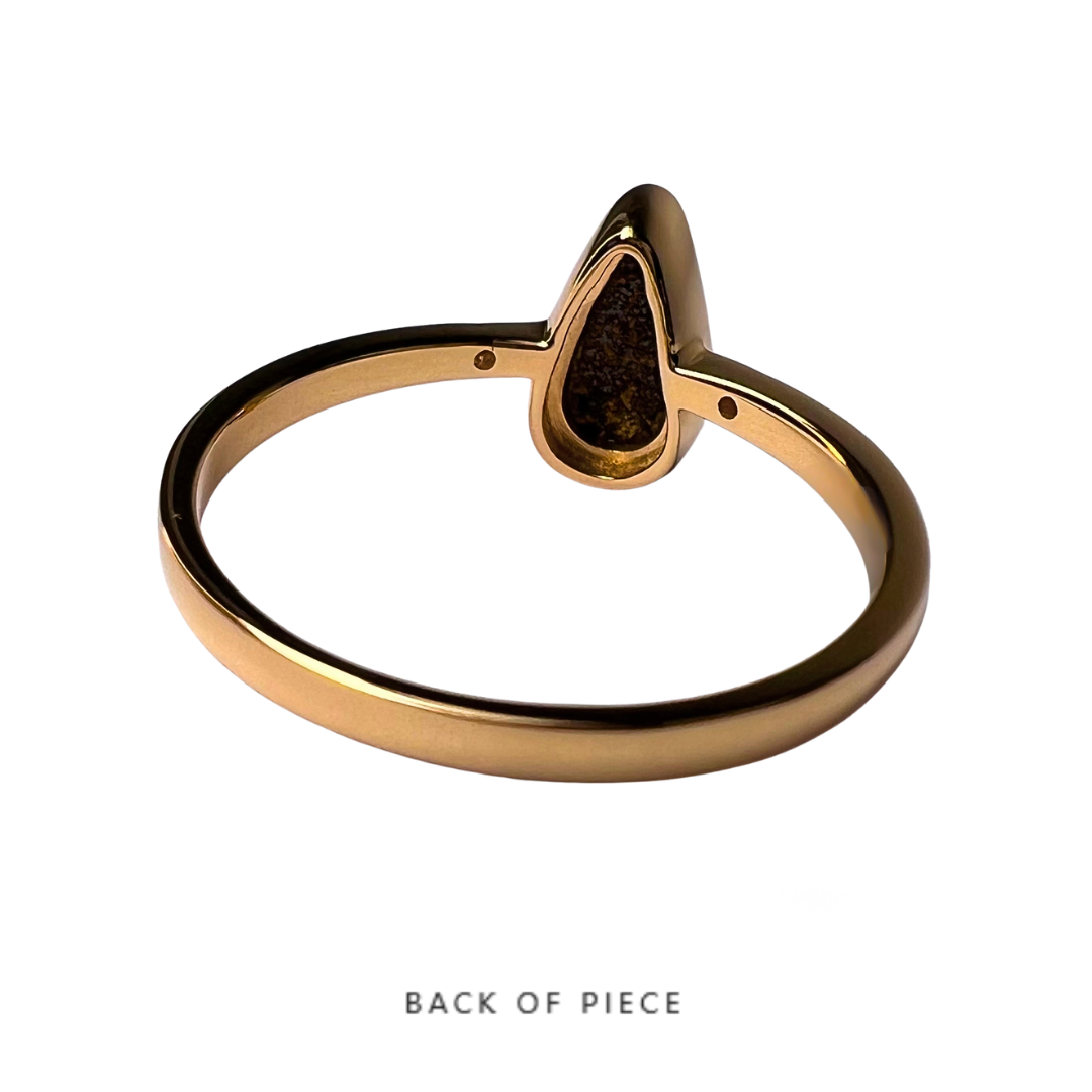 Gold ring with a teardrop-shaped opal from the back of the stone on a white background