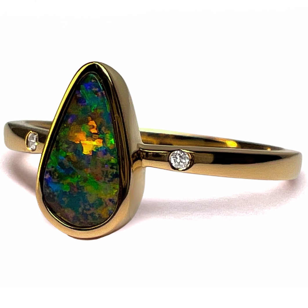 Gold ring with a colorful opal stone and small diamonds on a white background