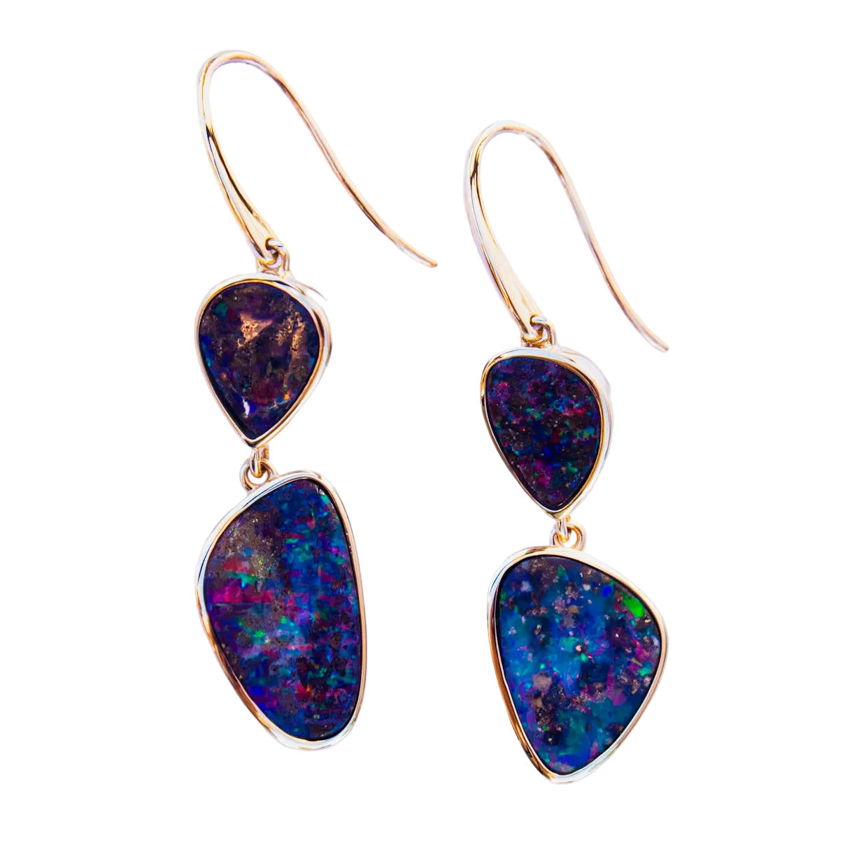 Pair of gold earrings with multicolored gemstones on a light white background