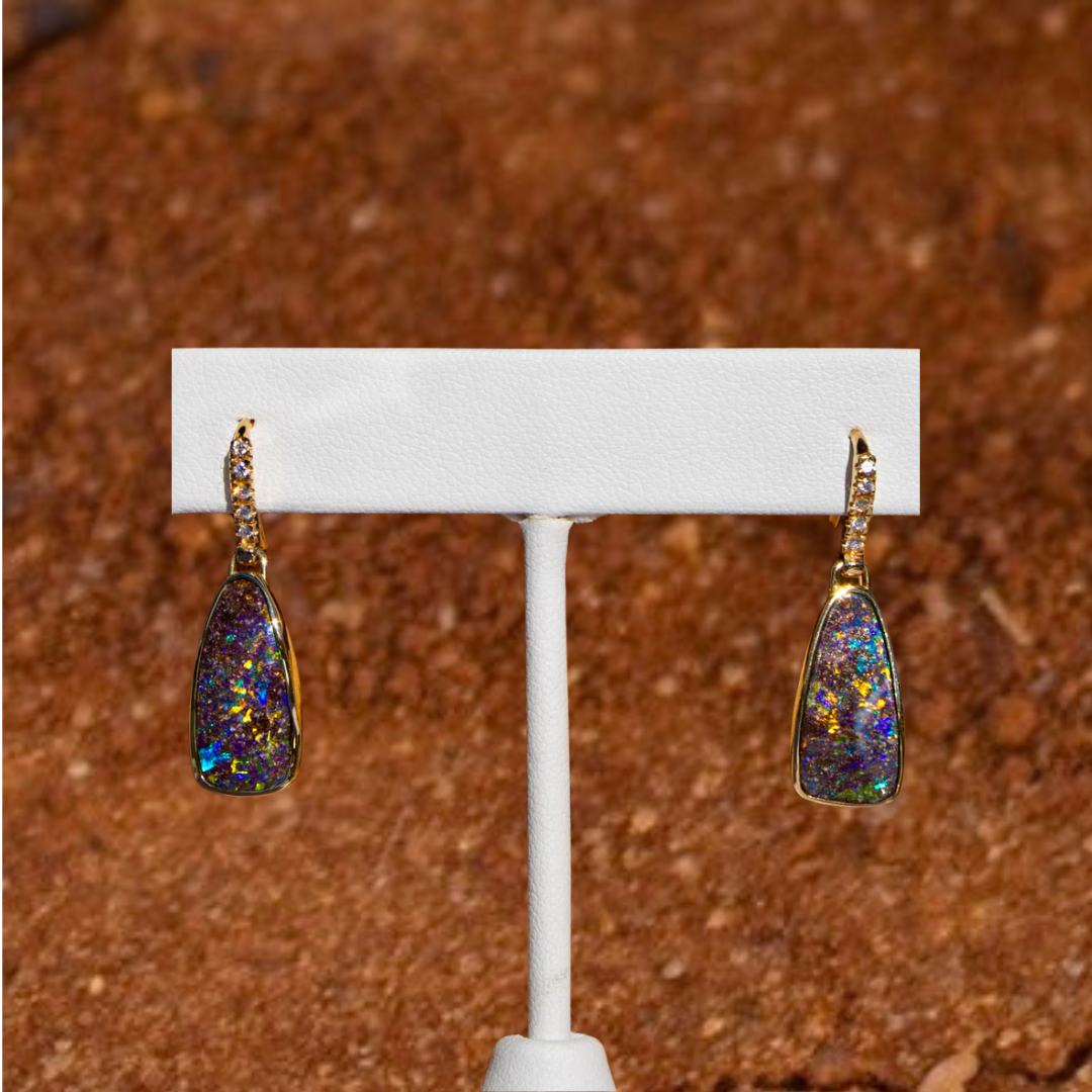 Showcasing the unique beauty of Australia's national gemstone, opal. These earrings feature two solid, natural and rare Australian Boulder Opals. Housed in solid 18K yellow gold, accent by beautiful VVS1 diamonds and featuring two beautiful boulder opals with dazzling blues, bright oranges and vivid greens.