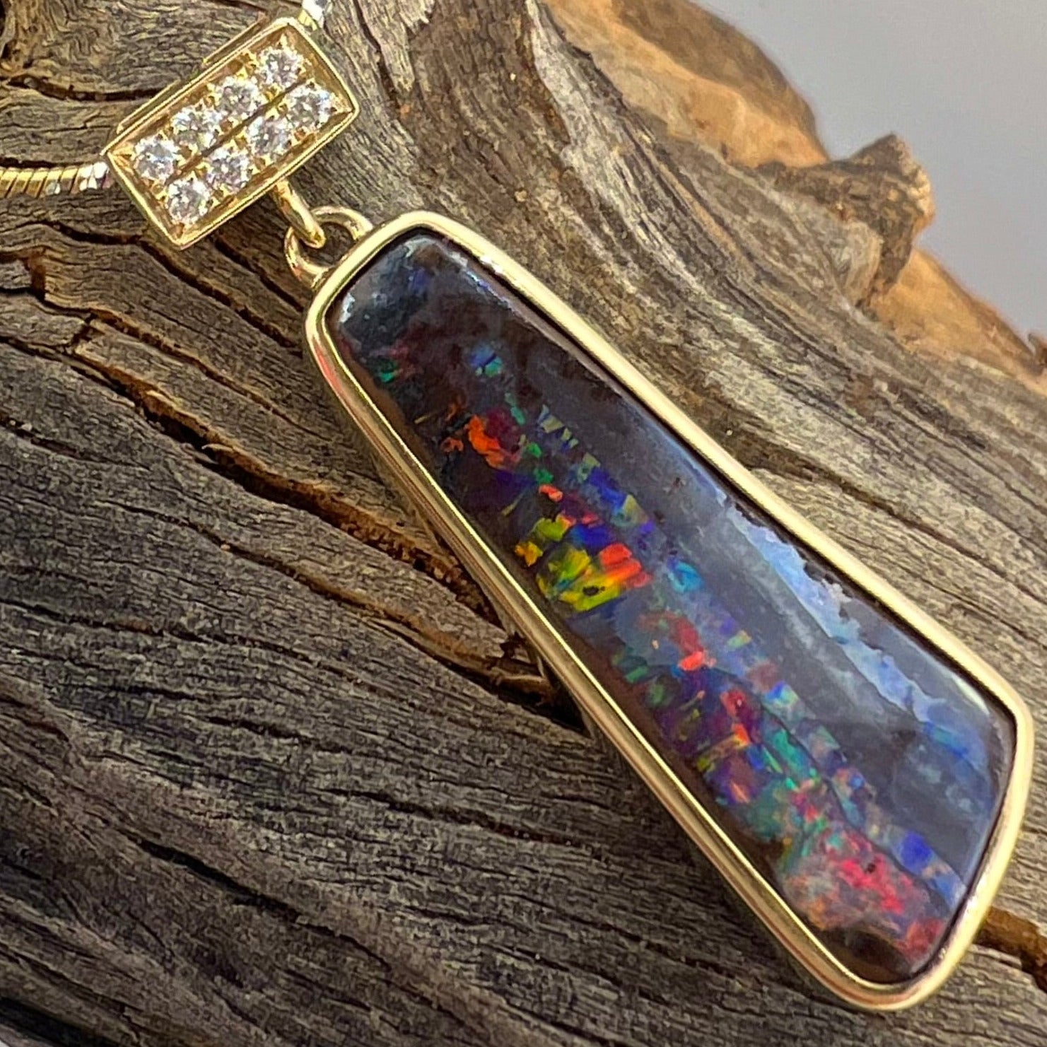 Opal pendant with gold frame on a wooden surface