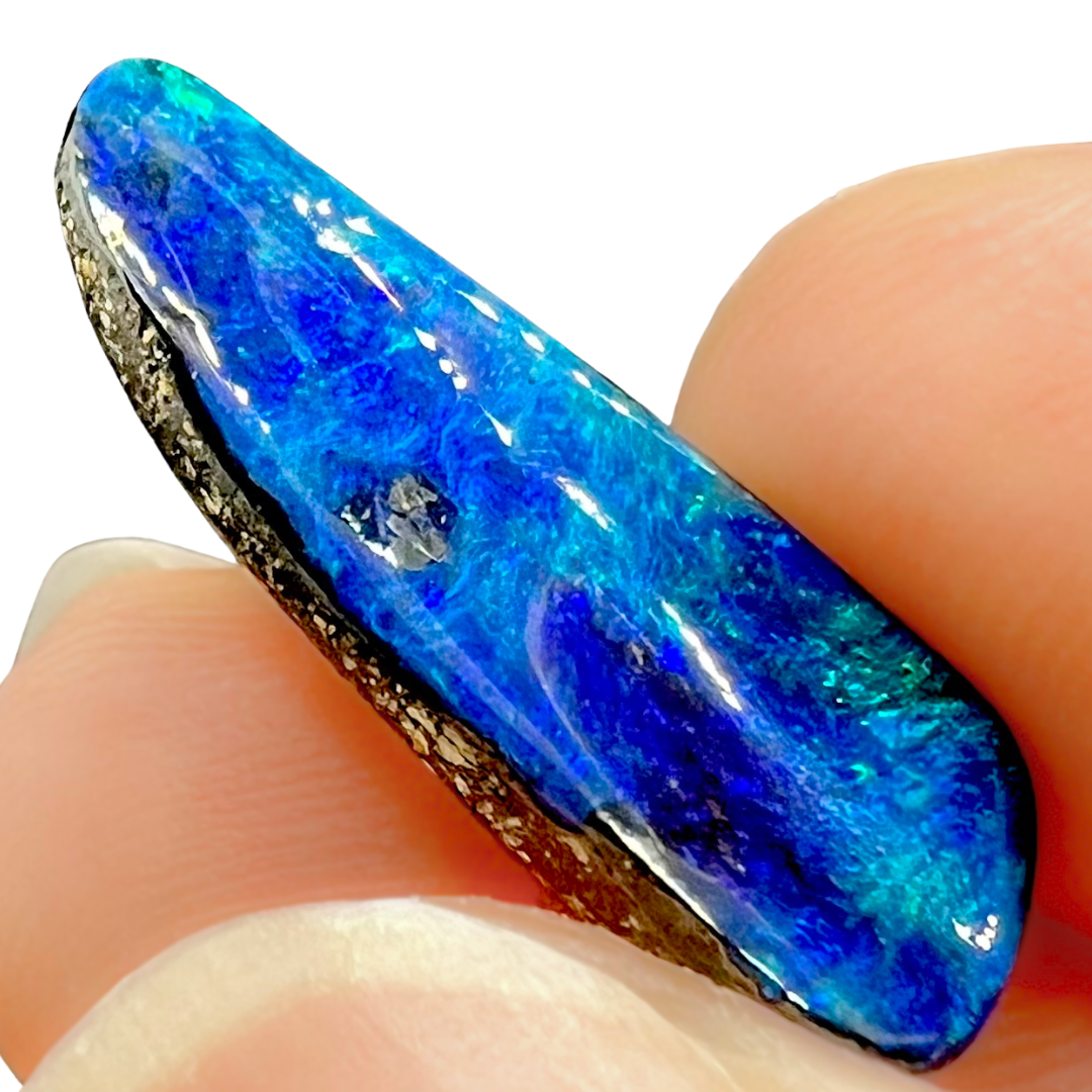 Blue opal stone held between fingers on a white background