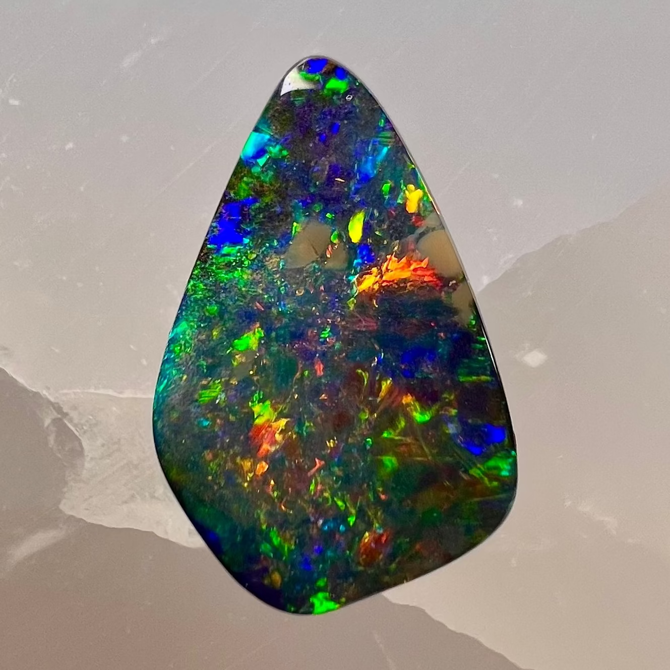 Multicolored opal stone on a gray background