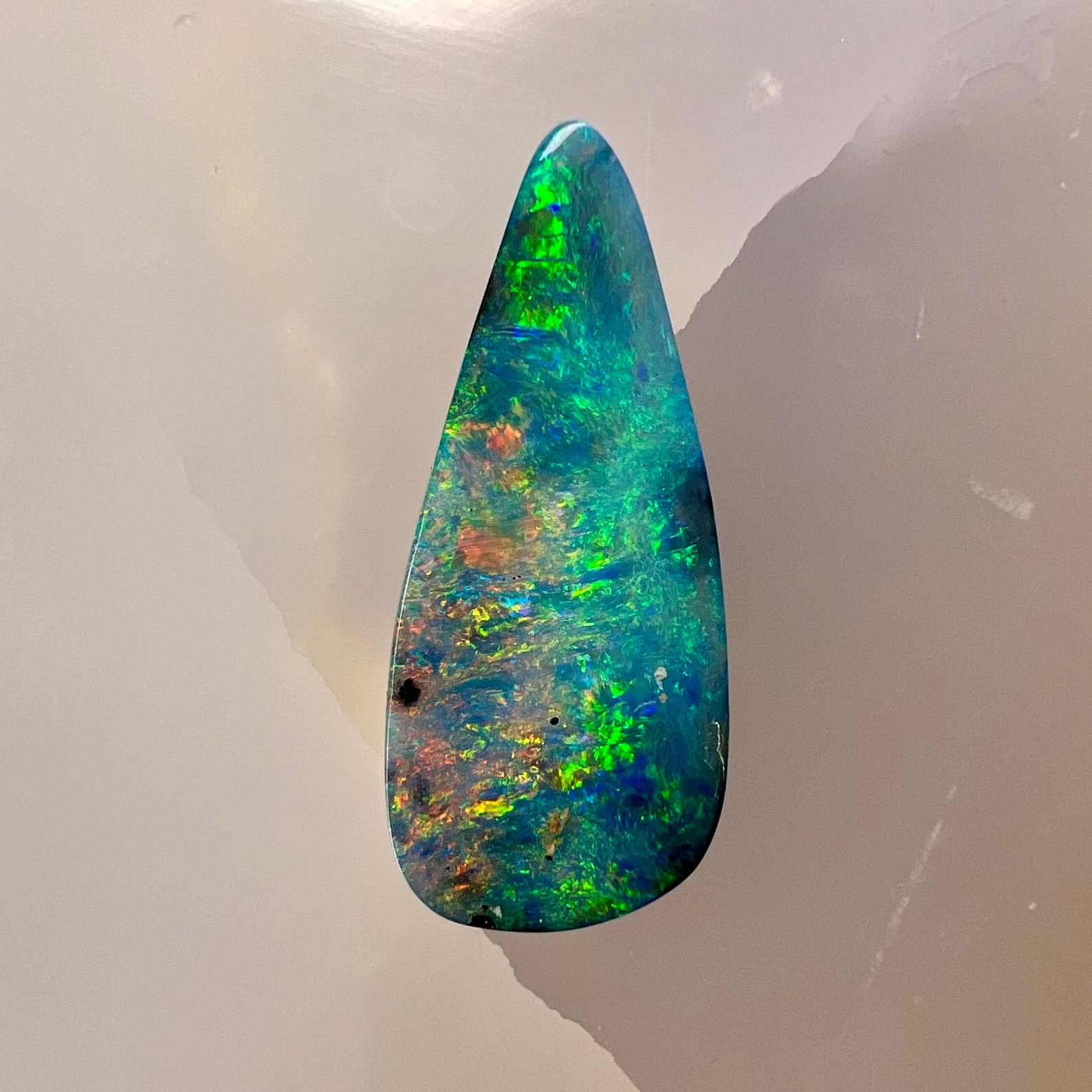 Multicolored opal stone on a white background