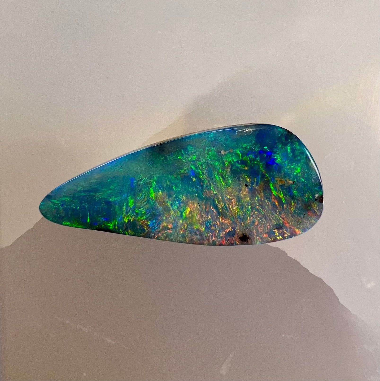 Multicolored opal stone on a light gray background