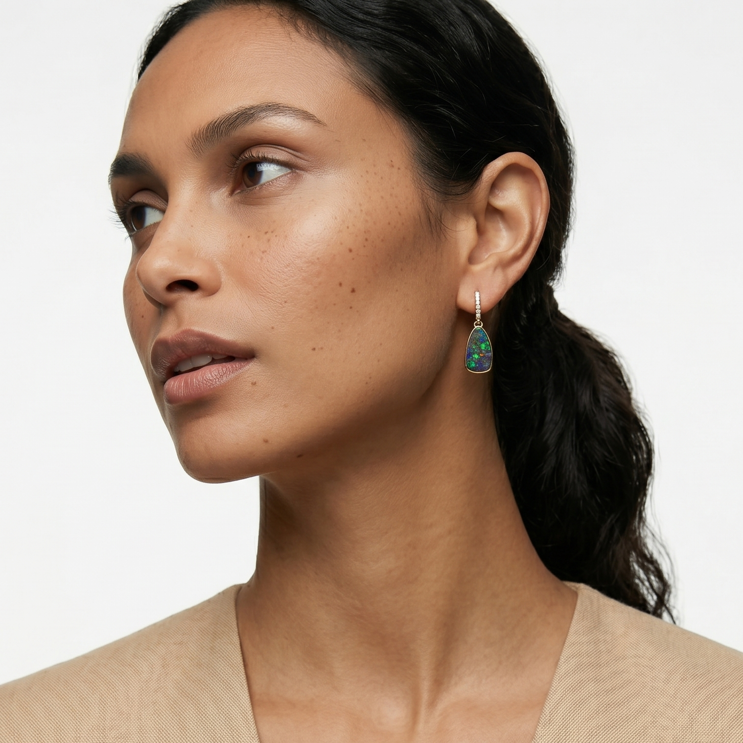 Woman wearing a beige top with a plain background